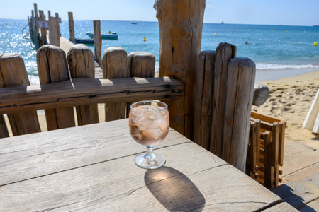 Summer party time in Provence, glass of rose wine with ice cubes on bar terrace Pampelonne sandy beach near Saint-Tropez in sunny day, Var department, Franceの写真素材