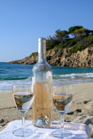 Summer time in Provence, two glasses of cold rose wine on sandy beach near Saint-Tropez in sunny day, Var department, France.の写真素材