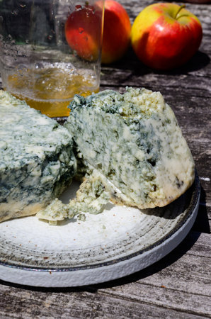 Cabrales blue cow's milk cheese and apple cider is glass made by rural farmers in Asturias, Spain, Las Arenas in Picos de Europa mountains, on old wooden tableの写真素材