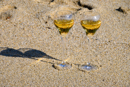 Summer time in Provence, two glasses of cold champagne cremant sparkling wine on sandy beach near Saint-Tropez in sunny day, Var department, vacation in Franceの写真素材