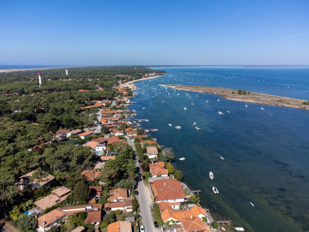 Aerial view on Arcachon Bay with many fisherman's boats and oysters farms, forest and red lighthouse Le Phare du Cap Ferret, Cap Ferret peninsula, France, southwest of Bordeaux, France's Atlantic coastlineの写真素材