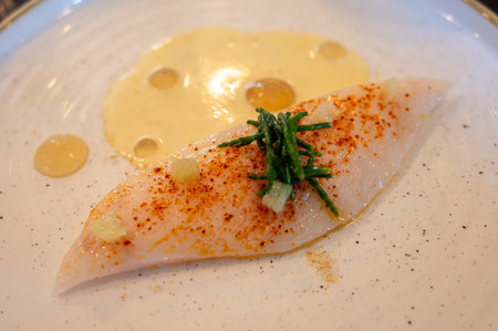 White fillet of most delicious fish John Dory, St Pierre or Peter's fish served with shell fish sauce in luxury restaurant in Bordeaux region, France, close upの写真素材