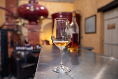 Tasting of cognac spirit aged in old dark French oak barrels in cellar in distillery house, Cognac white wine region, Charente, Segonzac, Grand Champagne, Franceの写真素材