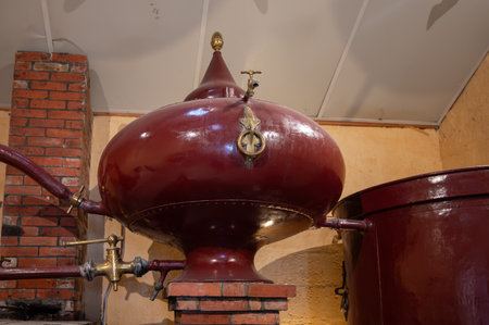 Double distillation process of cognac spirit in Charentias copper still pots and boilers in old distillery in Cognac white wine region, Charente, Segonzac, Grand Champagne, Franceの写真素材
