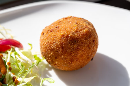 Tasty Italian street food, deep fried aranchini rice balls with different filling close upの写真素材