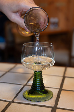 White quality riesling wine served in green swirl wine glass in old German restaurant in Monschau village, Germany close upの写真素材