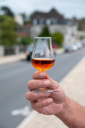 Tasting of aged in barrels cognac alcohol drink and view on old streets and houses in town Cognac, Grand Champagne, Charente, strong spirits distillation industry, Franceの写真素材