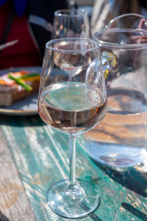 Drinking of pinot grigio dry cold wine, served outdoor in beach cafe in North Holland, North sea sandy beach, the Netherlandsの写真素材