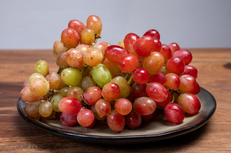 Sweet washed ripe pink grapes berries on board ready to eat close upの写真素材