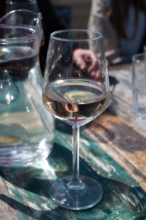 Drinking of pinot grigio dry cold wine, served outdoor in beach cafe in North Holland, North sea sandy beach, the Netherlandsの写真素材