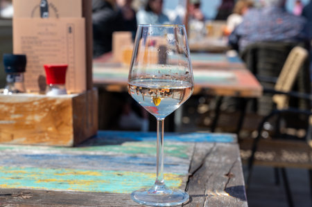 Drinking of pinot grigio dry cold wine, served outdoor in beach cafe in North Holland, North sea sandy beach, the Netherlandsの写真素材
