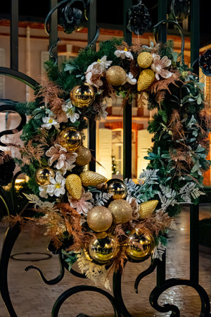 Christmas and New Year street decoration, round Christmas wreath hanging on metal gate, illuminated glass door at night, Epernay in Champagne, Franceの写真素材