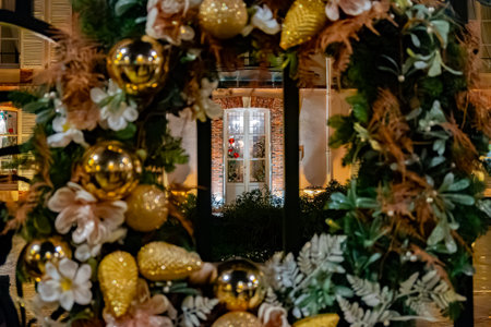 Christmas and New Year street decoration, round Christmas wreath hanging on metal gate, illuminated glass door at night, Epernay in Champagne, Franceの写真素材