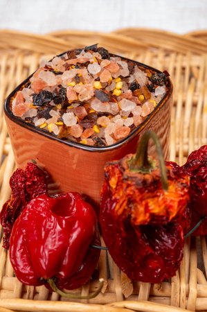 Pink himalayan salt crystals with dried seeds of red hot chili peppers and herbs, cooking with exotic salt, close upの写真素材