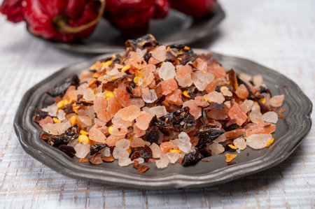 Pink himalayan salt crystals with dried seeds of red hot chili peppers and herbs, cooking with exotic salt, close upの写真素材