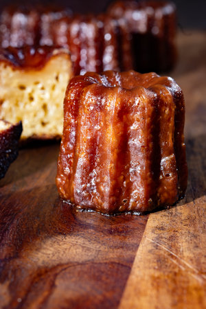 Canele, French pastry flavored with rum and vanilla, soft and tender custard center and dark, caramelized crust specialty of Bordeaux region, France close upの写真素材