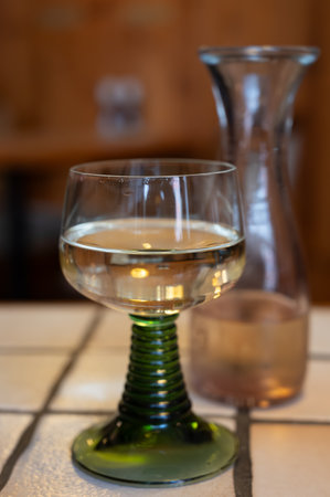 White quality riesling wine served in green swirl wine glass in old German restaurant in Monschau village, Germany close upの写真素材