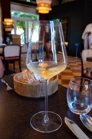 Tasting of Bordeaux white wine in Sauternes, left bank of Gironde Estuary, France. Glasses of white sweet French wine served in restaurantの写真素材