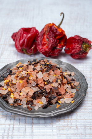 Pink himalayan salt crystals with dried seeds of red hot chili peppers and herbs, cooking with exotic salt, close upの写真素材