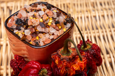 Pink himalayan salt crystals with dried seeds of red hot chili peppers and herbs, cooking with exotic salt, close upの写真素材