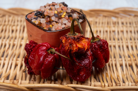 Pink himalayan salt crystals with dried seeds of red hot chili peppers and herbs, cooking with...
