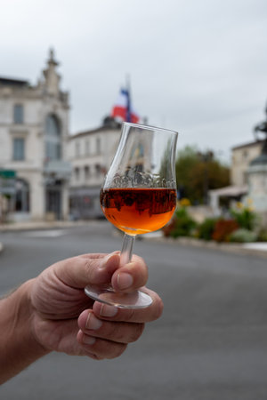 Tasting of aged in barrels cognac alcohol drink and view on old streets and houses in town Cognac, Grand Champagne, Charente, strong spirits distillation industry, Franceの写真素材
