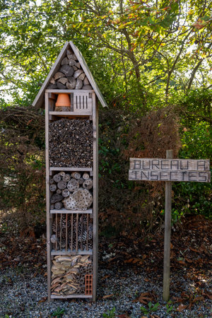 Handmade wooden insect hotel in garden in summer, english translation is office of insectsの写真素材