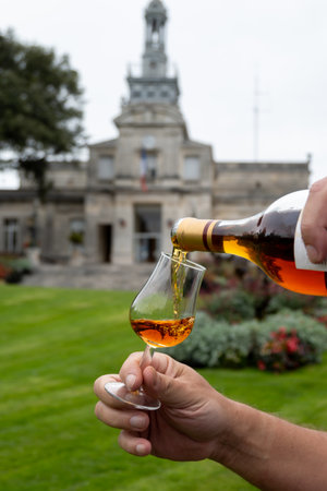 Tasting of aged in barrels cognac alcohol drink and view on old streets and houses in town Cognac, Grande Champagne, Charente, strong spirits distillation industry, Franceの写真素材