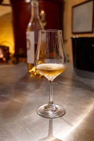 Tasting of cognac spirit aged in old dark French oak barrels in cellar in distillery house, Cognac white wine region, Charente, Segonzac, Grand Champagne, Franceの写真素材