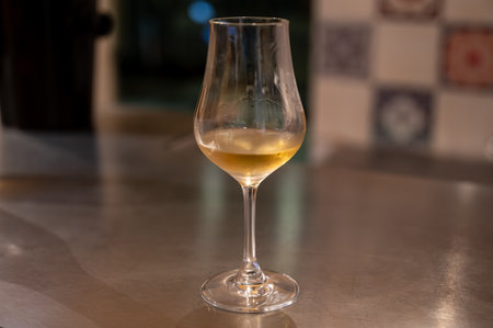 Tasting of cognac spirit aged in old dark French oak barrels in cellar in distillery house, Cognac white wine region, Charente, Segonzac, Grand Champagne, Franceの写真素材