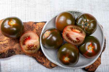 Fresh ripe sweet reddish brown and green kumato tomatoes close upの写真素材