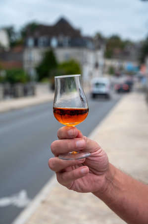 Tasting of aged in barrels cognac alcohol drink and view on old streets and houses in town Cognac, Grand Champagne, Charente, strong spirits distillation industry, Franceの写真素材