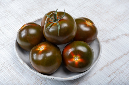 Fresh ripe sweet reddish brown and green kumato tomatoes close upの写真素材