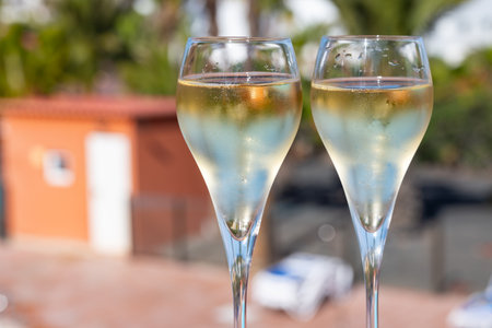 Pouring a glass of champagne on vacation, south of Fuerteventura, Canary islands, blue ocean, mountains, Spainの写真素材