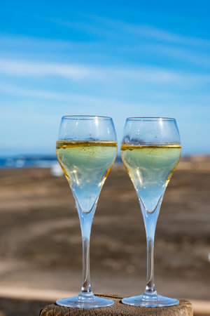 Pouring a glass of champagne on vacation, south of Fuerteventura, Canary islands, blue ocean, mountains, Spainの写真素材
