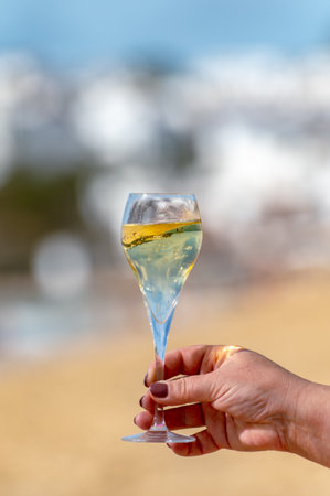 Pouring a glass of champagne on vacation, south of Fuerteventura, Canary islands, blue ocean, mountains, Spainの写真素材