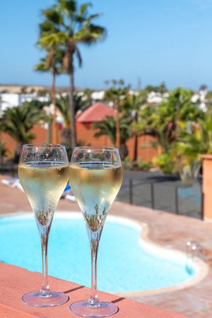 Pouring a glass of champagne on vacation, south of Fuerteventura, Canary islands, blue ocean, mountains, Spainの写真素材