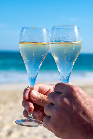 Pouring a glass of champagne on vacation, south of Fuerteventura, Canary islands, blue ocean, mountains, Spainの写真素材