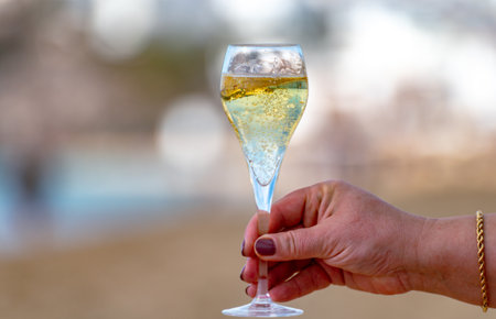Pouring a glass of champagne on vacation, south of Fuerteventura, Canary islands, blue ocean, mountains, Spainの写真素材