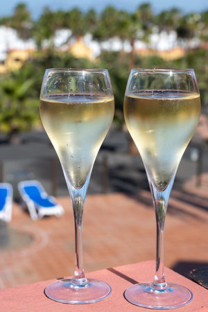 Pouring a glass of champagne on vacation, south of Fuerteventura, Canary islands, blue ocean, mountains, Spainの写真素材