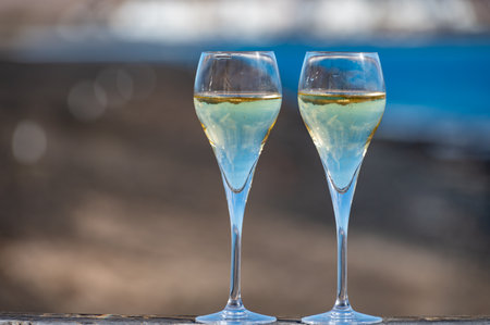 Pouring a glass of champagne on vacation, south of Fuerteventura, Canary islands, blue ocean, mountains, Spainの写真素材