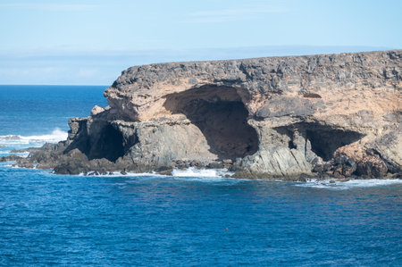 West coast of Fuerteventura island. View on blue water and black volcanic caves of Ajuy village, Canary islands, Spain.の写真素材
