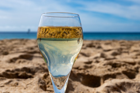 Pouring a glass of champagne on vacation, south of Fuerteventura, Canary islands, blue ocean, mountains, Spainの写真素材