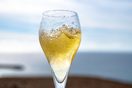 Pouring a glass of champagne on vacation, south of Fuerteventura, Canary islands, blue ocean, mountains, Spainの写真素材