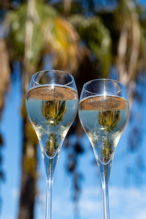 Pouring a glass of champagne on vacation, south of Fuerteventura, Canary islands, blue ocean, mountains, Spainの写真素材