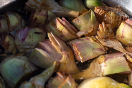 Bowl with lemon water and hearts of fresh purple romanesco artichoke vegetables close upの写真素材