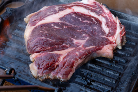 Large beef rib eye steak grilled on gas stove grill in small village restaurant in Tuscany, Italyの写真素材
