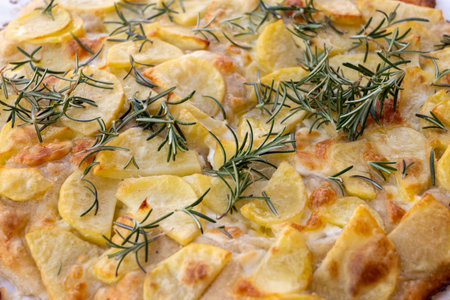 Fresh baked focaccia, pala romana pizza with potato vegetables and rosemary in bakery in Parma, Emilia Romania, Italyの写真素材