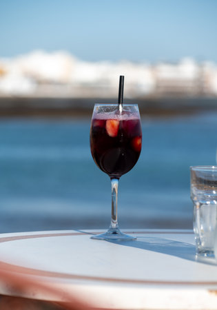 Glass of cold sangria sweet wine served with orange in beach cafe, Corralejo, Fuerteventura, Spainの写真素材