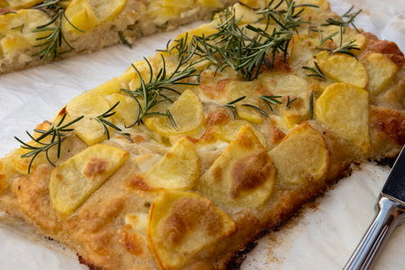 Fresh baked focaccia, pala romana pizza with potato vegetables and rosemary in bakery in Parma, Emilia Romania, Italyの写真素材